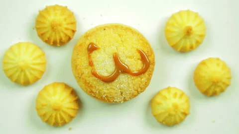 Butter biscuits with a painted figure surrounded by small cookies. Movement in a Stock Footage 98756681