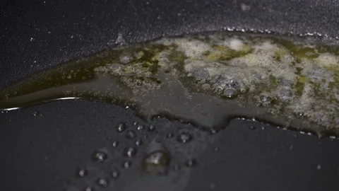 Butter melts and boils on a frying pan, close up Stock Footage 87585576