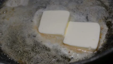 The butter melts in a ceramic pan Vidéo 150704328