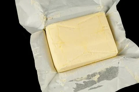 Butter in a pack opened black background Stock Photos