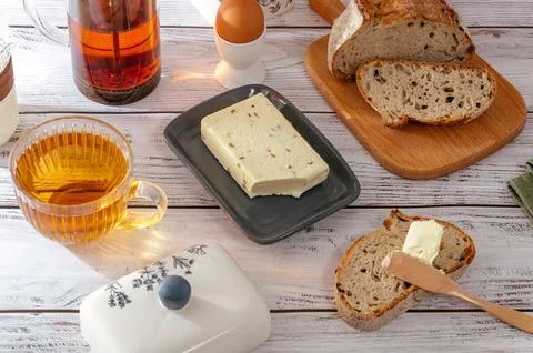 Butter is on a plate next to bread Stock Photos