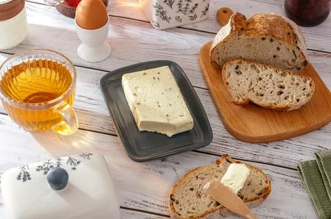 Butter is on a plate next to bread Stock Photos