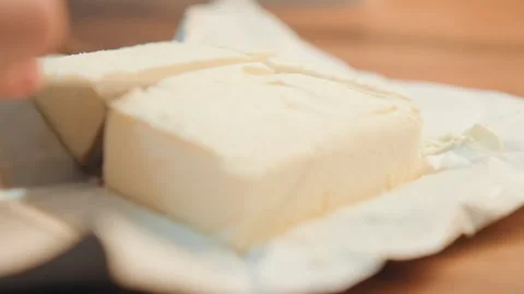 Butter slicing preparation. Preparing butter for baking. Cutting cold butter on Stock Footage 337453693