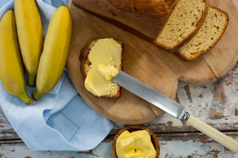 Butter spread on bread slice and bananas Stock Photos
