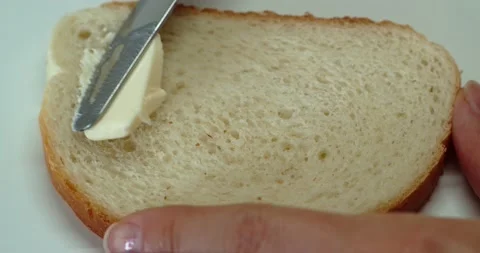 The butter is spread on the loaf with a knife Stock-Footage 155425557