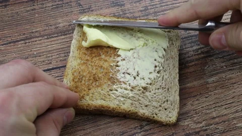 Butter spread on a slice of bread Stock Footage 150585550