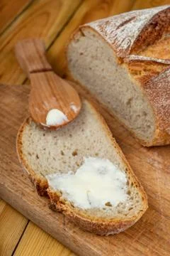 Butter spreading on fresh bread. Bread in the home kitchen. Foto stock
