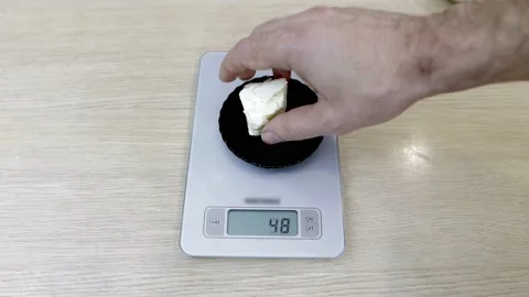 Butter is weighed on kitchen scales for baking Vídeo Stock 169699276