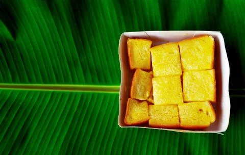 Buttered bread placed on four leafy banana leaves and a beautiful pattern. Foto stock