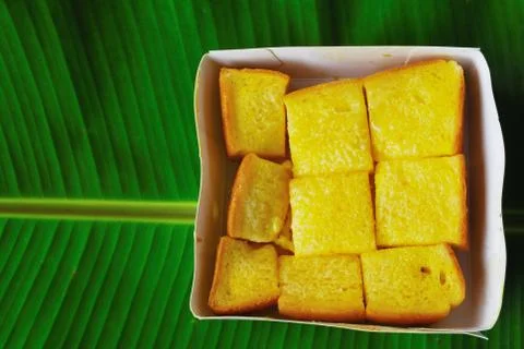 Buttered bread placed on four leafy banana leaves and a beautiful pattern. Stock Photos