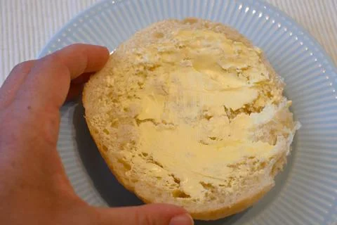 Buttered bread roll on a plate Stock Photos