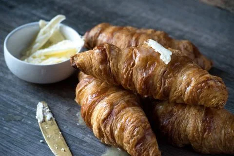 Buttered croissant rolls on rustic table Stock Photos