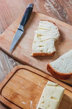 Buttered slice of homemade white bread and butter next to it top view copy space Stock Photos
