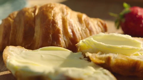 Buttering freshly baked croissants during breakfast Stock Footage 166159582