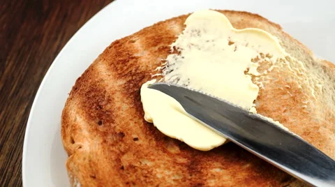 Buttering hot toast in slow motion with knife Stock Footage 46956618