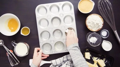 Buttering metal cupcake pan to bake cornbread muffins. Stock Footage 96355392