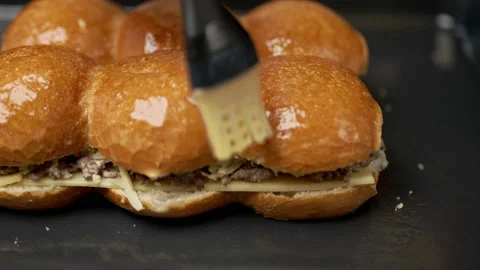 Buttering/brushing bread rolls with a pastry silicone brush in slow motion. Stock Footage 135464707