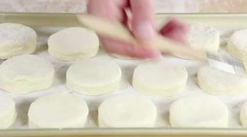 Buttermilk biscuits being brushed with egg yolk Stock Footage 24673079