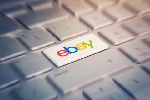 Button with the company logo ebay on the grey keyboard of a modern laptop. Stock Photos