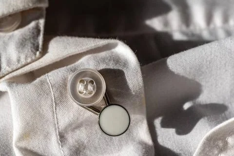 Button extender shown on a white dress shirt to increase size button exten... Stock Photos