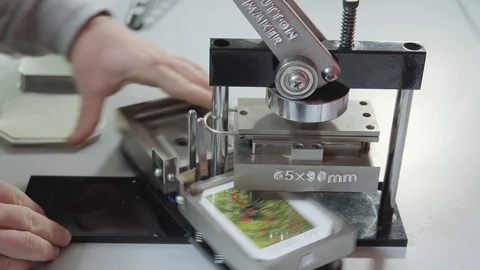Button maker machine with rectangular die molds. Man creating badges. Stock Footage 101258559