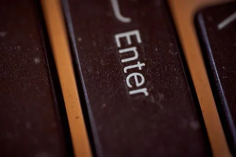 The button of an old laptop. Key Enter. Macro effect photo. Stock Photos