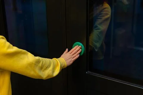 Button for opening doors on the train. Close-up of female hands on the green Stock Photos