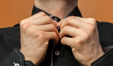 Buttoning a black shirt Stock Photos
