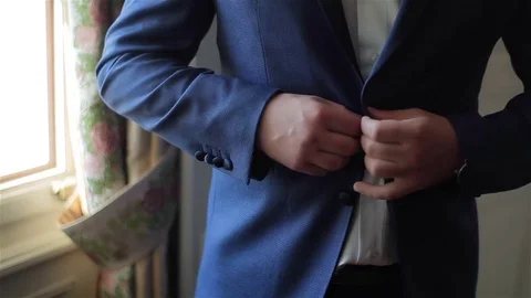 Buttoning a jacket hands close up. Stylish no face man in suit fastens buttons Stock Footage 70163872