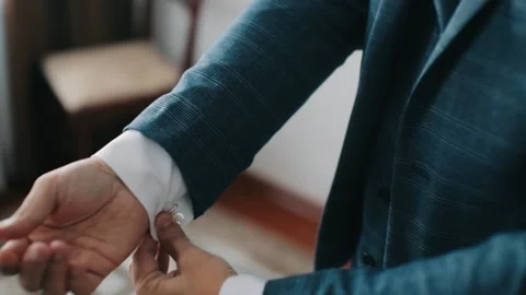 Buttoning a jacket hands close up. Stylish man in suit fastens buttons and Stock Footage 130599401