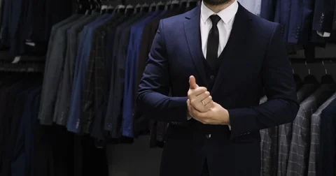 Buttoning a jacket. Stylish man in a suit fastening buttons on his jacket Video stock 76899306