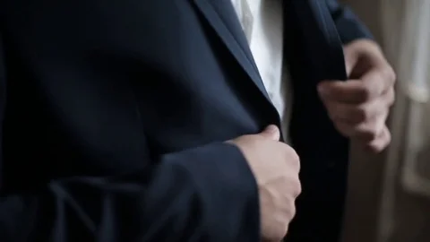 Buttoning a jacket. Stylish man in a suit fastening buttons on his jacket Stock Footage 81751316