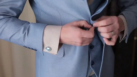Buttoning a jacket. Stylish man in a suit fastening buttons on his jacket Stock Footage 83222724