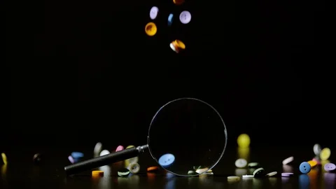 Buttons falling and a magnifying glass, Ultra Slow Motion Stock Footage 86577341