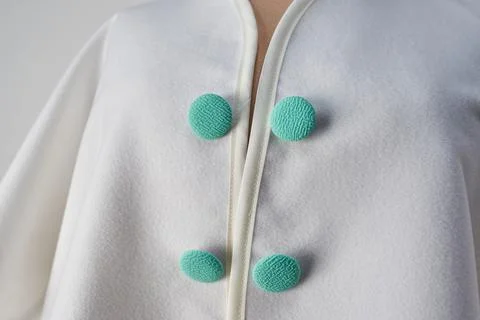 Buttons lined with calypso fabric on white coat. Author's design 스톡 사진