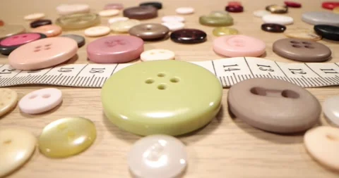 Buttons, needles, pins, spools and tailor's tape on wooden desk , close up. Stock-Footage 168249483