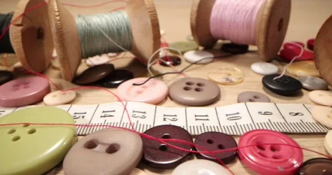 Buttons, needles, pins, spools and tailor's tape on wooden desk , close up. Stock-Footage 168249594