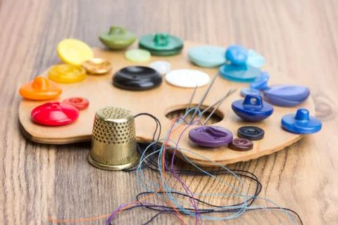 Buttons, thimble, needle and thread on the palette Foto stock