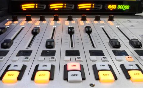 Buttons, volume levels, switches on the audio mixer control panel working on a Stock Photos