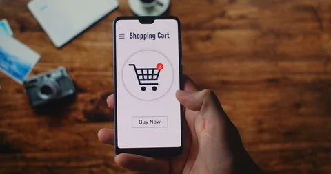 BUY NOW button being pressed on a smartphone screen. Woman at Home on Couch in Stock Footage 128687301