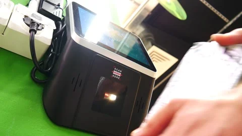 A buyer holds an item to a barcode scanner in a store to check the price Stock Footage 332153333