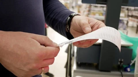 Buyer man checking a receipt for paying for groceries in a store near the cash r Stock Footage 283257190