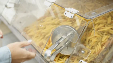 Buyer picks up pasta in store using scoop Stock Footage 121279153