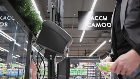 Buyer scans product through barcode scanner at self-service checkout ACO in Vidéo 219944394