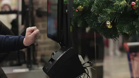 Buyer uses touch panel at self-service checkout ACO. Customer manually enters Video stock 219612911