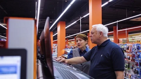 Buyers choose laptop and computer accessories at the store Stock Footage