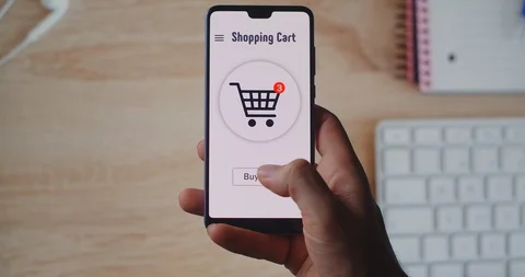 Buying goods in online store using smartphone application. Pressing the Buy Now Stock Footage 128687909