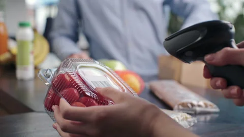 Buying healthy food at organic grocery store. Cashier using barcode reader for s Stock Footage 199485809