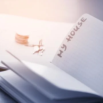 Buying a house. Keys and a stack of coins on the table. Foto stock