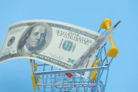 Buying a thermometer. thermometer and empty shopping trolley cart on blue b.. Stock Photos